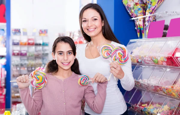 Mother with daughter holding candies in the shop — Stock Photo, Image