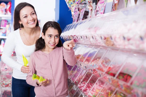 Woman with smiling girl choosing fruit jelly in shop — Stock Photo, Image