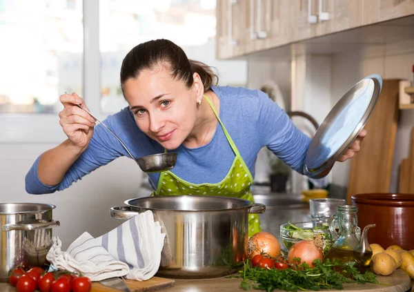 Positieve vrouw met kookpot op de keuken — Stockfoto