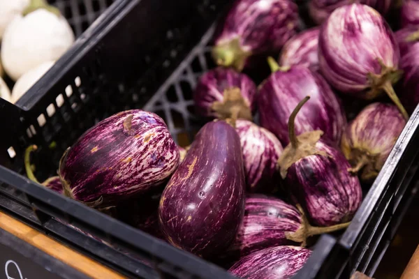 Caja de plástico con berenjena fresca en el mostrador del mercado — Foto de Stock