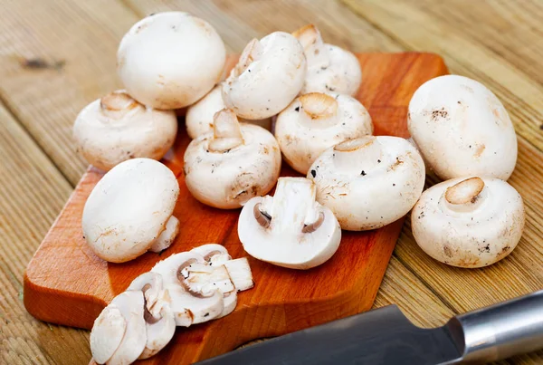 Champignons frais sur planche à découper en bois — Photo