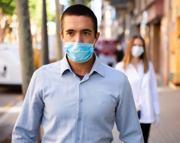 Hombre en mascarilla desechable caminando por la calle —  Fotos de Stock