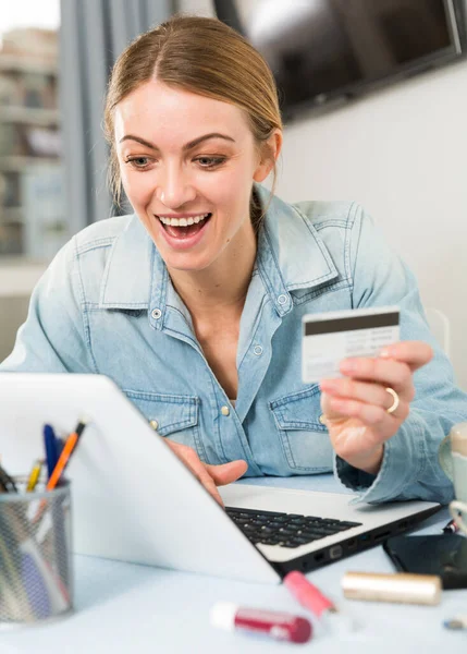 Menina comprando online com laptop e cartão de crédito em casa — Fotografia de Stock