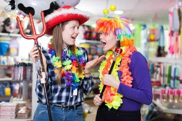 Chicas bromeando en la tienda de accesorios festivos —  Fotos de Stock