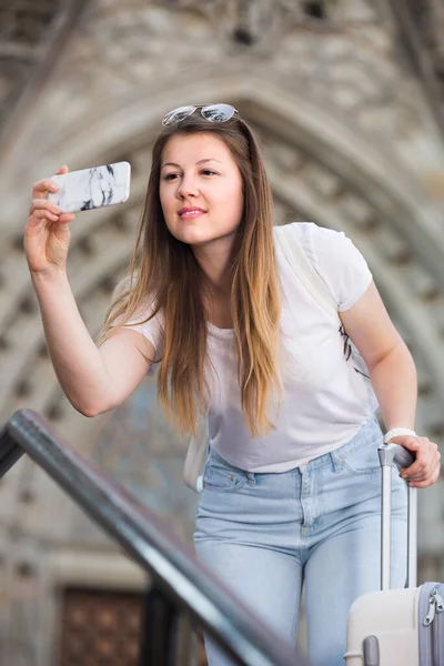 Menina alegre está tirando foto em seu telefone — Fotografia de Stock