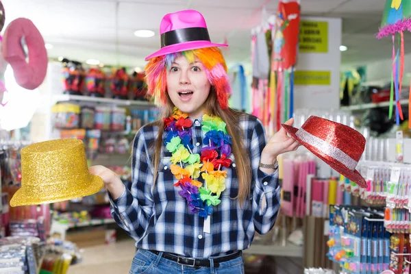 Κορίτσι που ψάχνει για αστεία καπέλα στο κατάστημα — Φωτογραφία Αρχείου