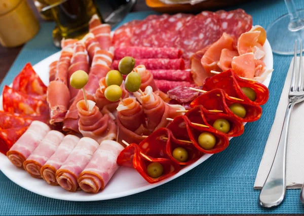 Cold cuts from ham, sausages, bacon on white plate — Stock Photo, Image