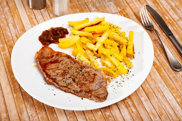 Steak de boeuf aux pommes de terre sur assiette blanche — Photo