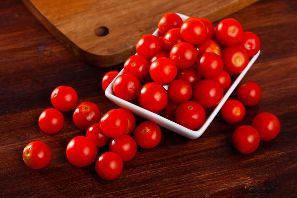 Tomates rojos cereza frescos enteros sobre mesa de madera. ingrediente vegetariano — Foto de Stock