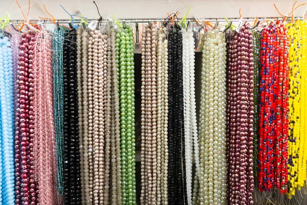 Beads from various semi-precious stones at the stand of jewelry store — Stock Photo, Image