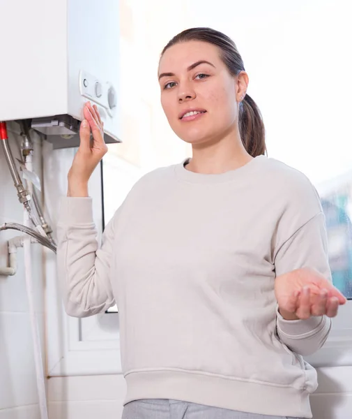 Retrato de mulher alegre que está de pé perto da coluna de gás na cozinha — Fotografia de Stock