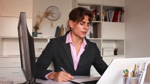 Радостный человек, работающий над ноутбуком в белой комнате — стоковое видео