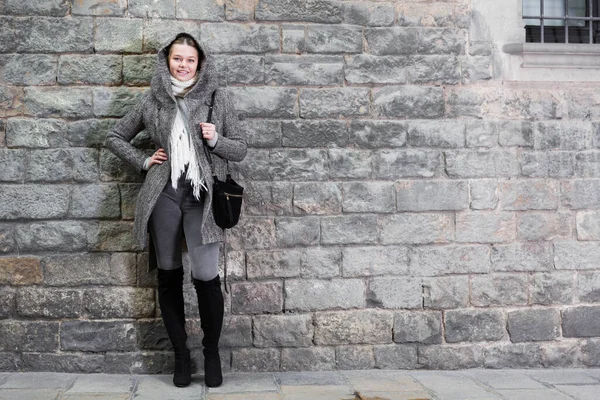 Ragazza in cappuccio in piedi vicino al muro di pietra — Foto Stock