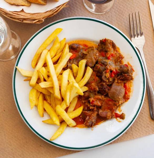 Stewed chicken gizzards in gravy with french fries — Stock Photo, Image