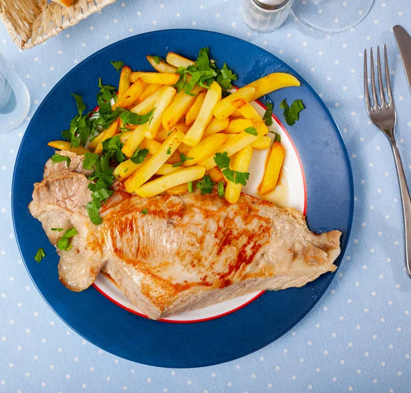 Porco frito apetitoso com batatas e ervas — Fotografia de Stock