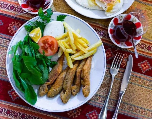 Pan-fried red mullet with fries, tomato, greens and lemon — Stock Photo, Image