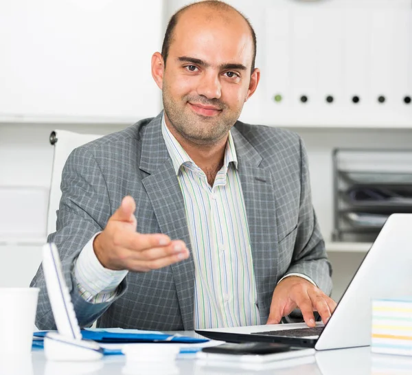 Man kantoormedewerker in grijze jas aanbieden van iemands hand — Stockfoto
