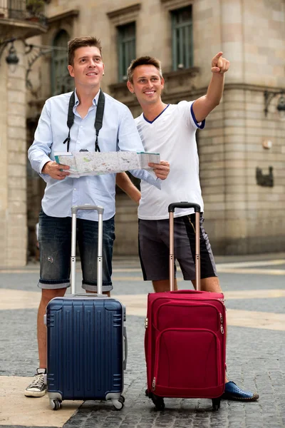 Turistas masculinos com mapa e bagagem — Fotografia de Stock