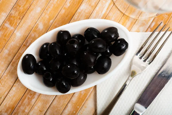 Eingelegte schwarze Oliven in weißer Schüssel — Stockfoto