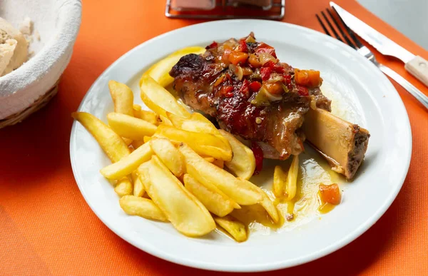 Varkensvlees gebakken schenkel met groenten en frietjes geserveerd — Stockfoto