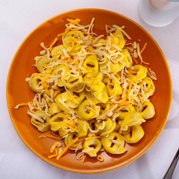 Tortellini gegarneerd met geraspte kaas en pignoli — Stockfoto