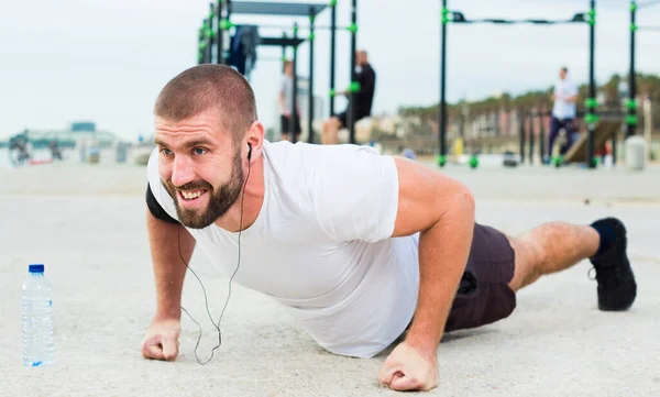 Mann macht Liegestütze auf Sportplatz — Stockfoto