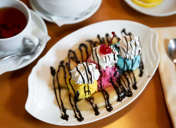 Banane à base de crème glacée fendue avec crème fouettée et sauce au chocolat — Photo