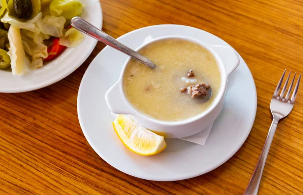Turecká polévka Paca corbasi podávaná s nakládanou zeleninou — Stock fotografie