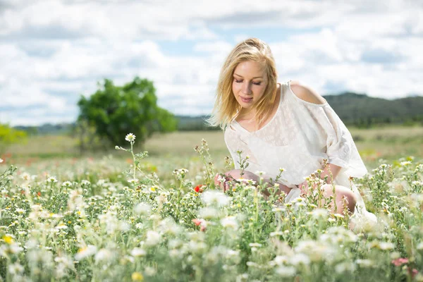 Young woman wearing white dress posing in fields with daisies flowers — Stock Photo, Image