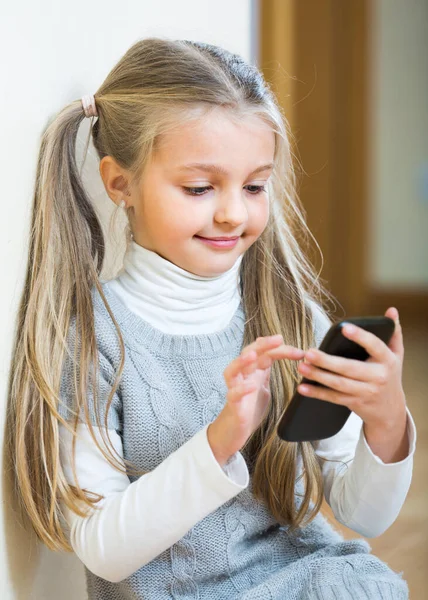 Little girl with cell phone indoors. — Stock Photo, Image