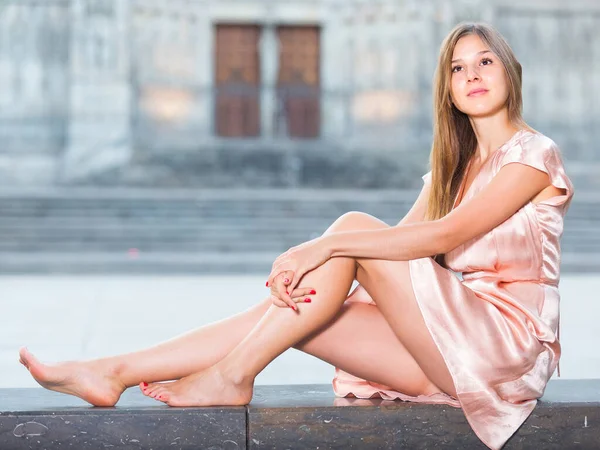 Chica joven en vestido romántico sentado en la ciudad — Foto de Stock