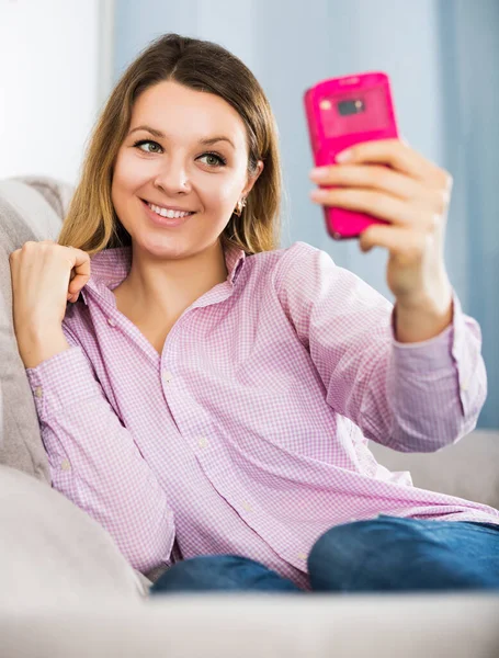 Vrouw controleren haar telefoon en het nemen van selfies — Stockfoto