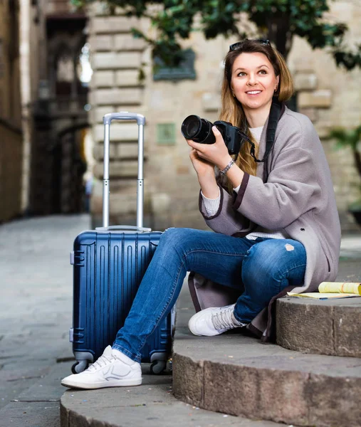 Chica sosteniendo la cámara en las manos y fotografiando en la ciudad — Foto de Stock