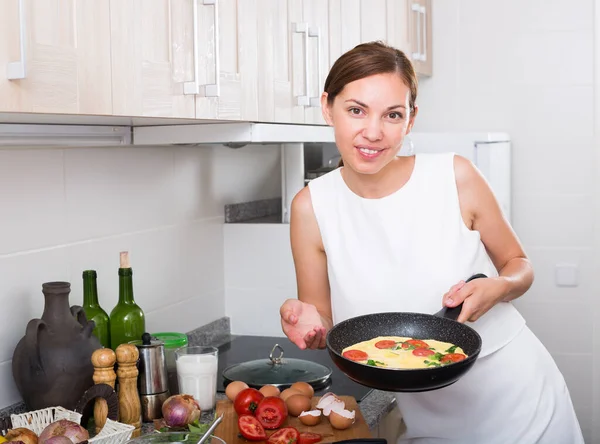 Kobieta przygotowuje omlet na patelni — Zdjęcie stockowe