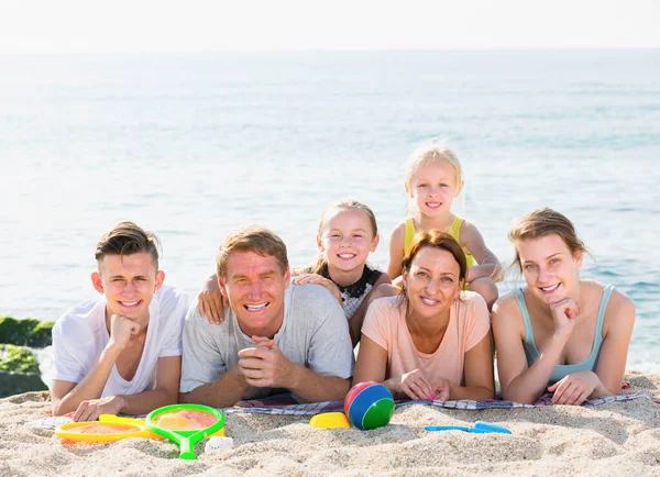 해변에 함께 누워 있는 여섯 식구의 가족 — 스톡 사진