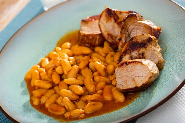 Heerlijk gebakken varkensvlees met bonen in jus op bord — Stockfoto