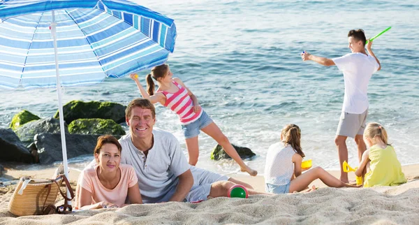 Büyük bir aile sahilde dinleniyor. — Stok fotoğraf