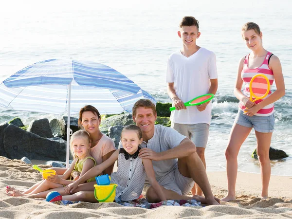 Szczęśliwa rodzina z dziećmi razem na plaży siedzi — Zdjęcie stockowe