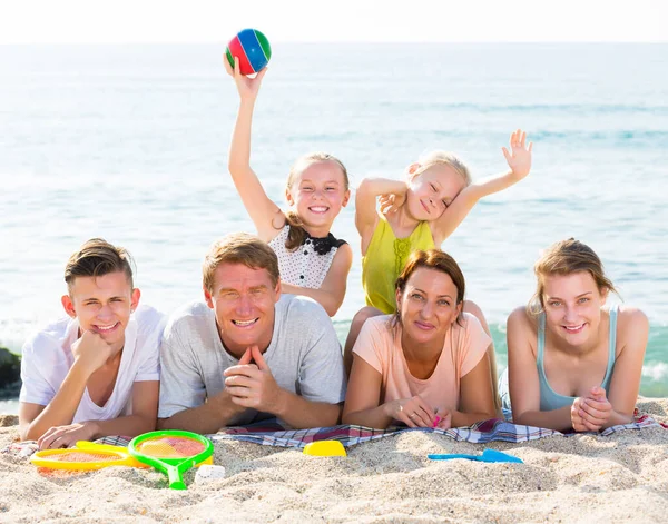 Ouders met kinderen liggend op zand — Stockfoto