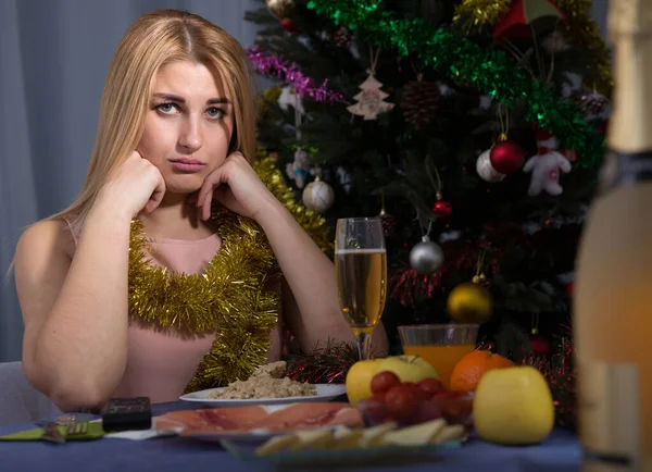 Jonge vrouw drinkt champagne en verveelt zich alleen in nieuwjaarsavond — Stockfoto