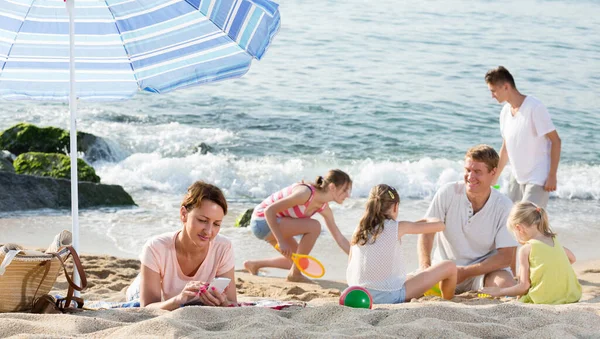 Familie mit vier Kindern entspannt am Strand. — Stockfoto
