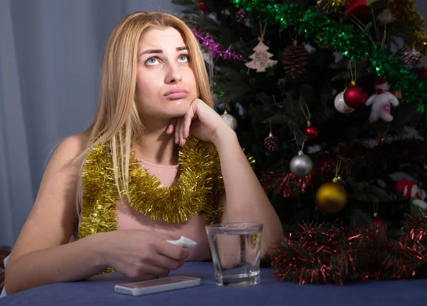 Девушка скучает и пьет воду в новогоднюю ночь — стоковое фото