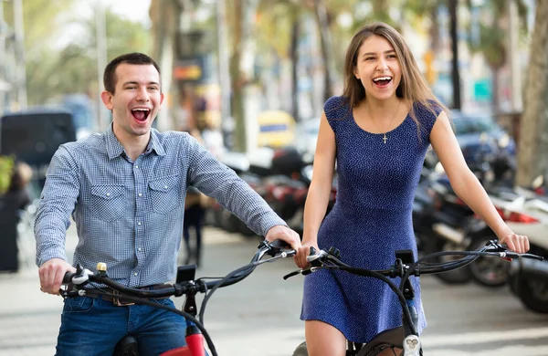 Gelukkige jongeman en vrouw met electrkc fietsen — Stockfoto