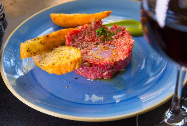 Gros plan de savoureux steak de veau tartare servi à plat bleu avec des toasts — Photo