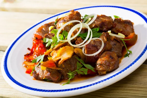 Carne de porco frita cozida com pimentas, cogumelos e cebola na chapa — Fotografia de Stock
