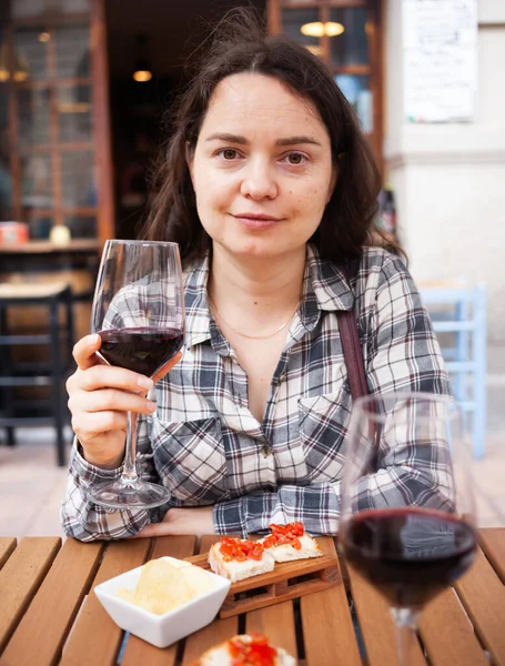 Donna sulla terrazza aperta del ristorante con vino e snack — Foto Stock