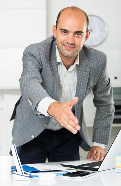 Man kantoormedewerker in grijze jas aanbieden van iemands hand — Stockfoto