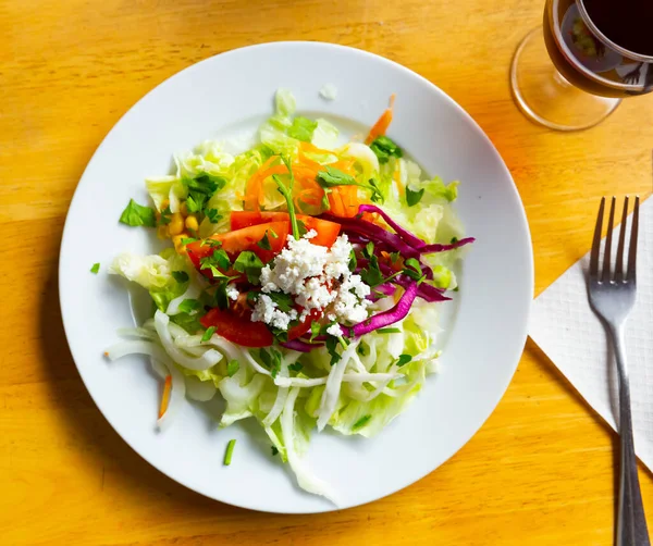Овощной салат из свежего салата, помидоров, кукурузы, лука, тертой моркови и петрушки — стоковое фото