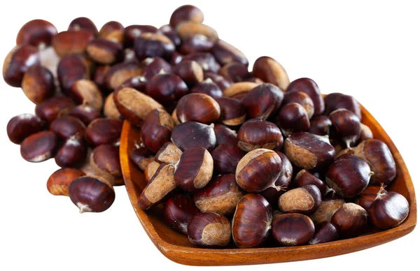 Raw edible chestnuts in wooden bowl on table — Stock Photo, Image