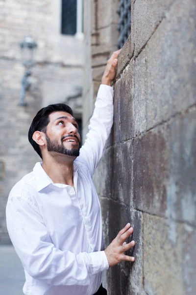 Чоловік намагається піднятися на кам'яну стіну — стокове фото